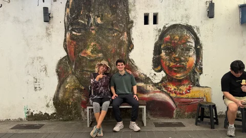 Rodrigo in front of a mural in Malaysia